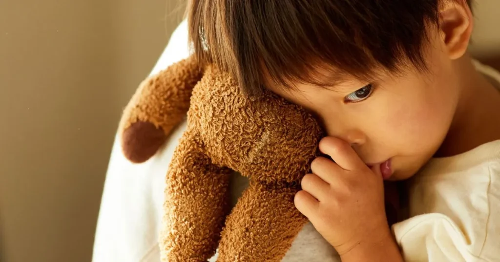 ぬいぐるみを抱える子ども