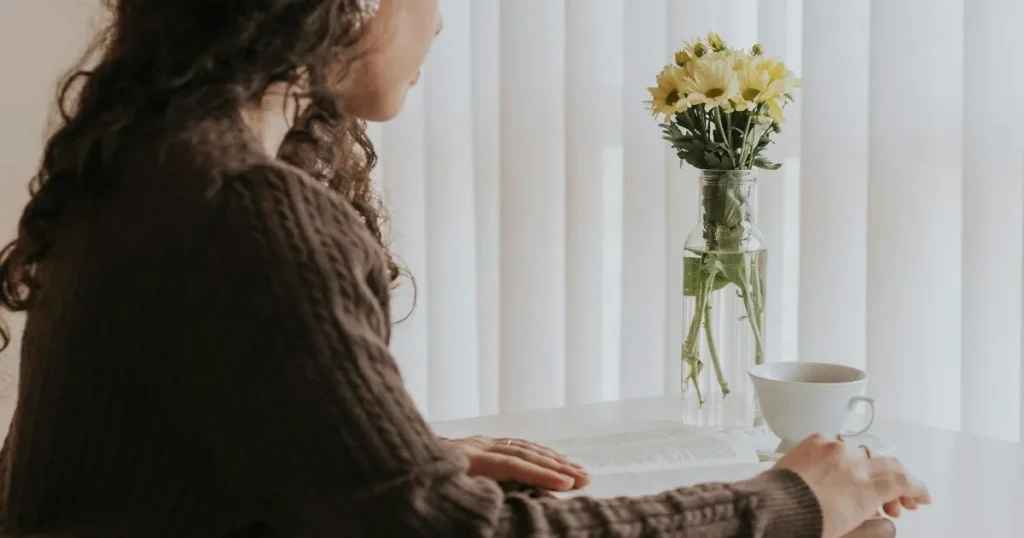 窓辺に立つ女性の後ろ姿