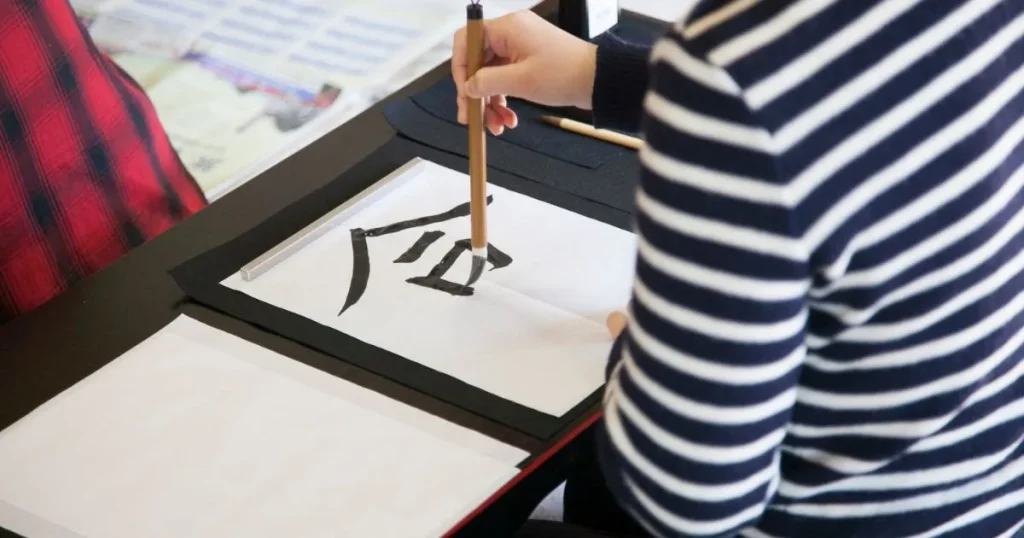 子どもが筆で文字を書いている手元の写真