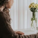 窓辺に立つ女性の後ろ姿