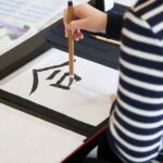 子どもが筆で文字を書いている手元の写真
